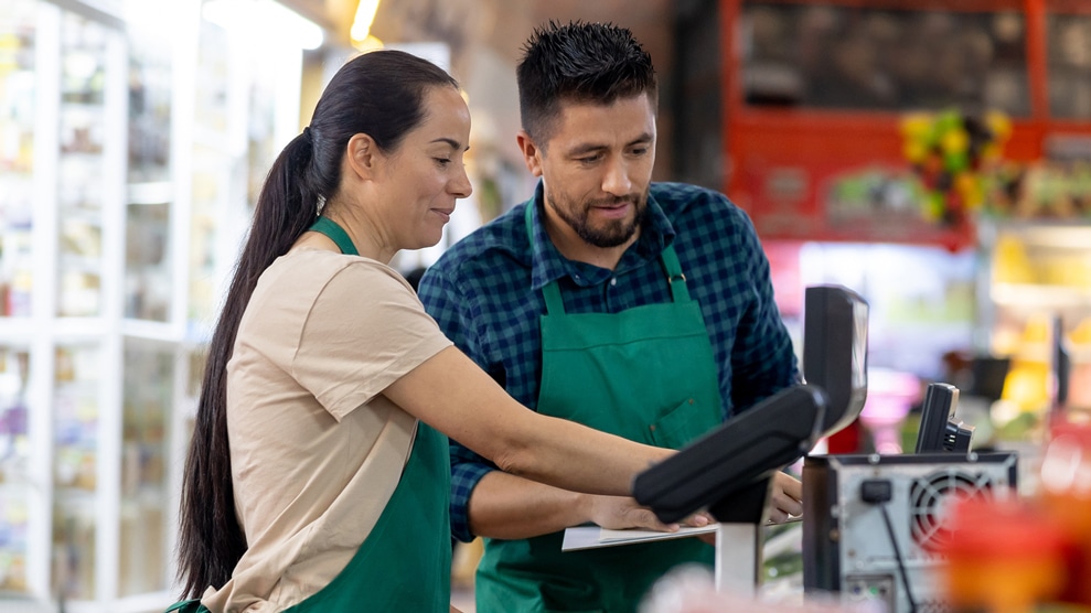 two people conversing at a grocery store checkout