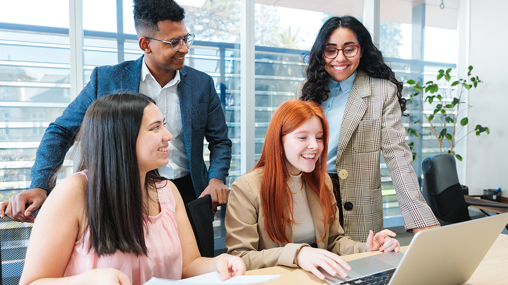 Gen Z workers gathered around in an office