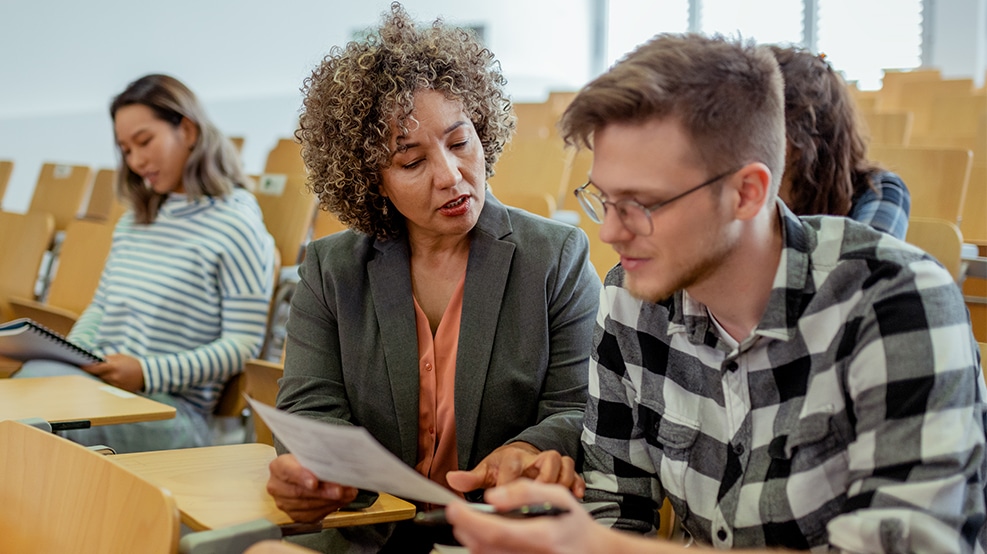 teacher reviewing document with a student