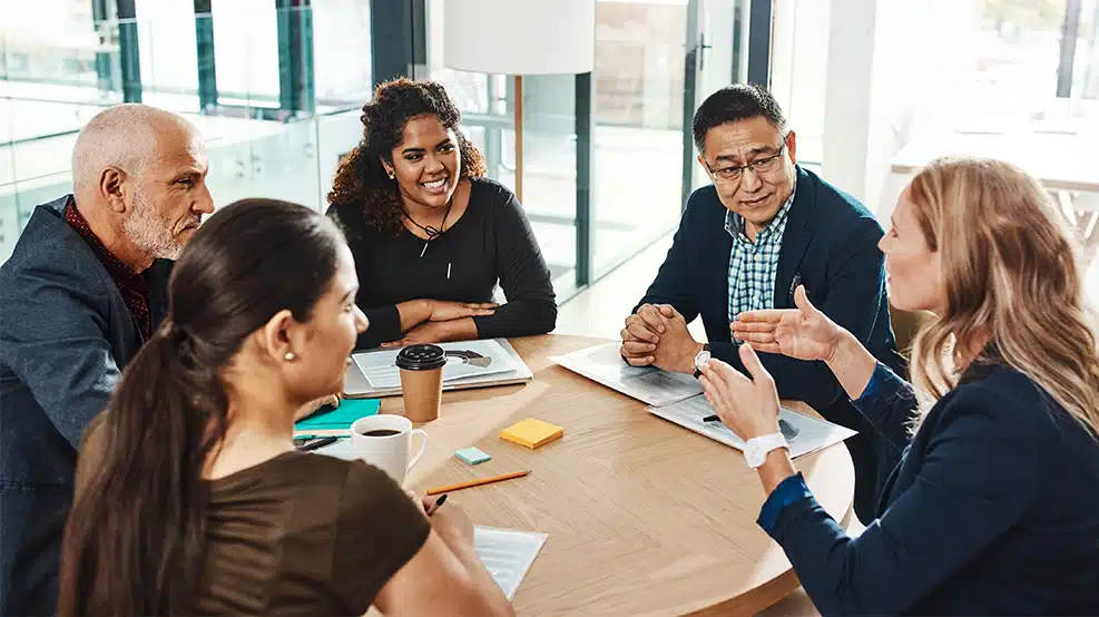 diverse group of people sitting at an office table